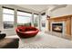 Open living room boasts a cozy fireplace, large windows with backyard views and unique red sofa at 23965 E Kettle Pl, Aurora, CO 80016