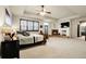 Large main bedroom showcases a fireplace, tray ceiling with ceiling fan, and plush carpeting at 23965 E Kettle Pl, Aurora, CO 80016