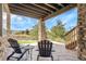 Charming covered patio with stone columns, outdoor seating, and lovely backyard views at 23965 E Kettle Pl, Aurora, CO 80016