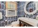 Stylish bathroom showcases modern herringbone tile design, elegant sink, and decorative round mirror at 824 S Medea Way, Denver, CO 80209