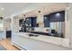 Modern kitchen with navy cabinets, stainless steel appliances, and a quartz countertop at 824 S Medea Way, Denver, CO 80209