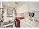 Bright laundry room with window features a washer, dryer, utility sink, and plenty of storage at 824 S Medea Way, Denver, CO 80209