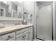 Bright bathroom with a walk-in shower, framed mirror, and white cabinets at 4070 S Atchison Way # 304, Aurora, CO 80014