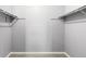 Empty walk-in closet with metal rods for hangers and neutral paint at 4070 S Atchison Way # 304, Aurora, CO 80014