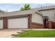 Charming townhome featuring a two-car garage, brick accents, and well-maintained landscaping at 5161 S Emporia Way, Greenwood Village, CO 80111