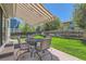 Relaxing backyard with awning over outdoor table and chairs and large lawn at 11034 W Aqueduct Ln, Littleton, CO 80127