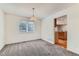 Bright dining room with modern light fixture and view into the kitchen at 11034 W Aqueduct Ln, Littleton, CO 80127