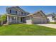 Charming gray two-story home with manicured lawn and brick accents on a sunny day at 11034 W Aqueduct Ln, Littleton, CO 80127