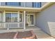 Inviting front porch with gray siding, white trim, and a charming bay window at 11034 W Aqueduct Ln, Littleton, CO 80127