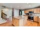 Bright kitchen features a center island, wood cabinets, stainless steel appliances, and hardwood floors at 11034 W Aqueduct Ln, Littleton, CO 80127