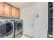 Modern laundry room featuring new washer and dryer, and plenty of storage cabinets at 11034 W Aqueduct Ln, Littleton, CO 80127