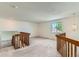 Spacious loft area with wooden railings, a window, and neutral carpet at 11034 W Aqueduct Ln, Littleton, CO 80127