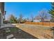 Spacious backyard with a wood fence, a patio area perfect for outdoor entertaining and mature trees at 16543 E Kansas Pl, Aurora, CO 80017