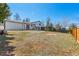Large backyard with a wooden fence, mature trees, and a patio, ideal for outdoor activities and relaxation at 16543 E Kansas Pl, Aurora, CO 80017