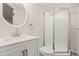 Bright bathroom with a glass enclosed shower, stylish vanity, a large mirror and modern fixtures at 16543 E Kansas Pl, Aurora, CO 80017