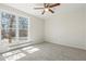 Cozy bedroom with a ceiling fan, large window, and plush carpeting for added comfort at 16543 E Kansas Pl, Aurora, CO 80017