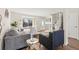 Open-concept living room with hardwood floors, large bright windows, and access to front entrance and staircase at 16543 E Kansas Pl, Aurora, CO 80017