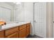 Bathroom featuring a single sink with wood cabinets, a large mirror, and a white door at 1953 E 102Nd Cir, Thornton, CO 80229