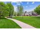 Scenic view of a lush green community park with a walking path leading to playground equipment at 1953 E 102Nd Cir, Thornton, CO 80229