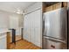 Hallway with wood floors, utility closet, stainless steel refrigerator, and a gate at 1953 E 102Nd Cir, Thornton, CO 80229