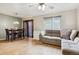 Open concept living area with a dining table, gray sectional sofa, wood floors, and abundant natural light at 1953 E 102Nd Cir, Thornton, CO 80229