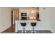 Kitchen bar with marble counters, black bar stools, and black appliances at 1020 15Th St # 20F, Denver, CO 80202