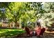 The landscaped backyard includes mature trees, lush lawn, a back deck, and a cozy outdoor seating area at 57 Mc Intyre Cir, Golden, CO 80401