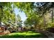 This home offers a beautifully landscaped backyard with mature trees, a garden area and an outdoor seating area at 57 Mc Intyre Cir, Golden, CO 80401