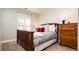 Cozy bedroom featuring wood-framed bed, white and red pillows, wood dresser, and white shutters at 57 Mc Intyre Cir, Golden, CO 80401