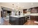 Spacious eat-in kitchen with stainless steel appliances, dark wood cabinets, and view to living room at 57 Mc Intyre Cir, Golden, CO 80401