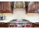 Chef's kitchen featuring stainless range, modern hood, tiled backsplash and granite counters at 57 Mc Intyre Cir, Golden, CO 80401