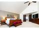 Comfortable bedroom featuring a vaulted ceiling, large window, wooden furniture, and entry to another area at 57 Mc Intyre Cir, Golden, CO 80401