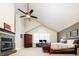 Bright bedroom featuring a stone fireplace, vaulted ceiling, large window, and comfortable furniture at 57 Mc Intyre Cir, Golden, CO 80401