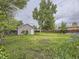 Large backyard featuring mature trees, green grass, a storage shed and privacy fence at 5339 S Windermere St, Littleton, CO 80120