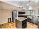 Modern kitchen with granite countertops, an island, stainless steel appliances, and hardwood floors at 5339 S Windermere St, Littleton, CO 80120