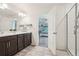 Bathroom featuring a double vanity, a glass-enclosed shower, and a view to the bedroom at 1846 Osprey Dr, Brighton, CO 80601
