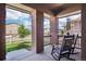 Charming covered porch featuring rocking chairs, brick columns, and a serene view of the neighborhood at 1846 Osprey Dr, Brighton, CO 80601