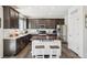 Modern kitchen featuring dark wood cabinets, stainless steel appliances, large island, and a pantry at 1846 Osprey Dr, Brighton, CO 80601