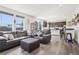 Open-concept living room and kitchen with hardwood floors and large windows showcasing the backyard at 1846 Osprey Dr, Brighton, CO 80601