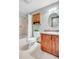 Cozy bathroom features shower over tub, wooden cabinets and a granite vanity at 7290 Lamar Ct, Arvada, CO 80003