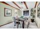 Charming dining room featuring exposed beams, chandelier lighting, and an adjacent kitchen with stainless steel appliances at 7290 Lamar Ct, Arvada, CO 80003