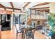 Charming dining area featuring hardwood floors, wood beams, and natural light from front door view at 7290 Lamar Ct, Arvada, CO 80003