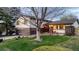 Charming two-story home with a well-manicured lawn and inviting front porch seating area at 7290 Lamar Ct, Arvada, CO 80003
