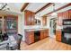 Well-lit kitchen with wood cabinets, modern appliances, hardwood floors, and access to an outdoor deck at 7290 Lamar Ct, Arvada, CO 80003
