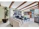 Comfortable living room with exposed wood beams, ample seating, and view of stairs to the second floor at 7290 Lamar Ct, Arvada, CO 80003