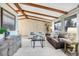 Cozy living room featuring exposed beams, comfortable seating, and natural light from multiple windows at 7290 Lamar Ct, Arvada, CO 80003