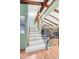Carpeted staircase leading to a bright upper level with wooden beams and decorative railing at 7290 Lamar Ct, Arvada, CO 80003