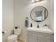 Half bathroom with a round mirror and grey vanity with gold fixtures at 4542 Valleybrook Dr, Highlands Ranch, CO 80130