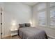 Cozy bedroom with a queen bed, side tables, and window with plantation shutters at 4542 Valleybrook Dr, Highlands Ranch, CO 80130