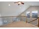 View of bonus room features vaulted ceiling, windows with custom shutters, and wood and iron railing at 4542 Valleybrook Dr, Highlands Ranch, CO 80130